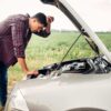 a man stands in front of a car with the hood open