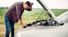 a man stands in front of a car with the hood open