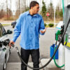 A man fills up with petrol at a gas station on the highway