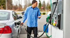 A man fills up with petrol at a gas station on the highway