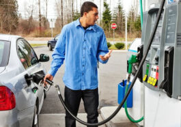 A man fills up with petrol at a gas station on the highway