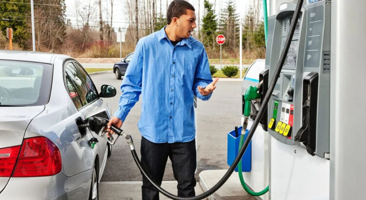 A man fills up with petrol at a gas station on the highway