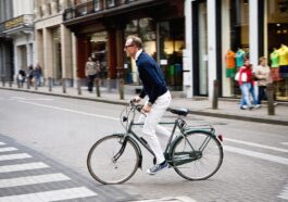 A man rides a bicycle in an urban environment