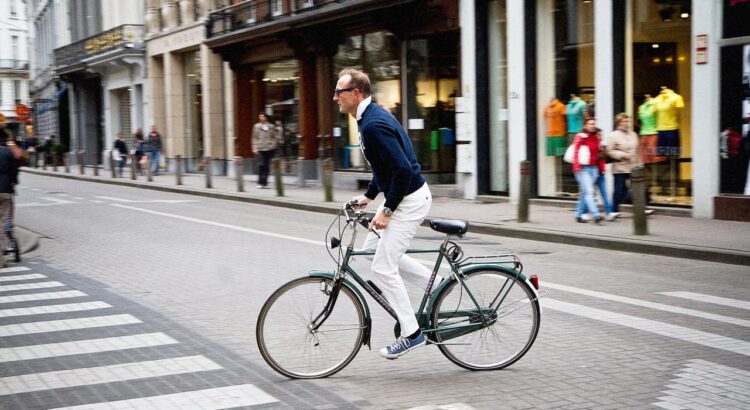 A man rides a bicycle in an urban environment