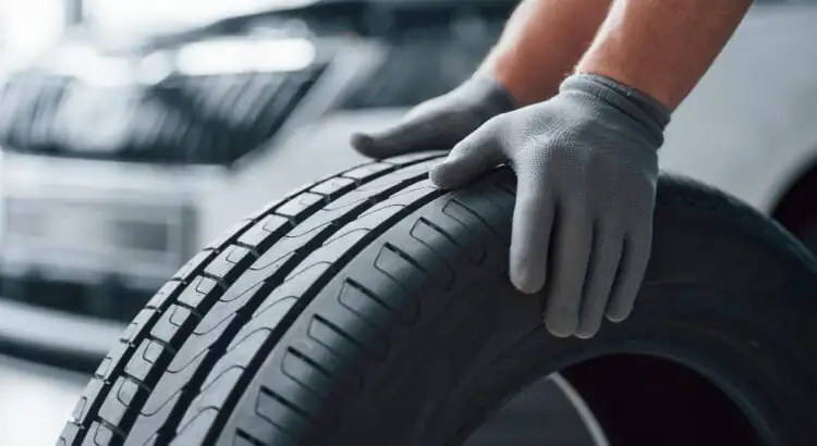 Какво трябва да знаем за гумите Michelin 195/65r15 91t TL Alpin 6? - hands only mechanic holding tire repair garage replacement winter summer tires 750x410 1