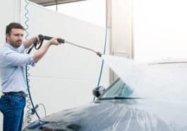 a man washes his car at a self-service car wash